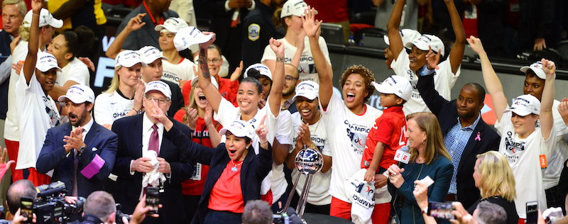 The Washington Mystics celebrate with the championship trophy after its 89-78 win in Game 5 of the WNBA finals at the Entertainment and Sports Arena in D.C. on Oct 10. (John E. De Freitas/The Washington Informer)