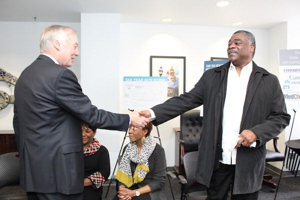 Baltimore Orioles legend Eddie Murray (right) shakes hands with Maryland Comptroller Peter Franchot before a Jan. 27 press conference in Baltimore to kick off opening day of the state's health insurance enrollment program. (Brigette Squire/The Washington Informer)