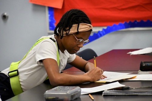 Jalah Berrian, a fifth grade student at William Beanes Elementary School in Suitland, jots down notes during a class discussion on climate change. (Anthony Tilghman/The Washington Informer)