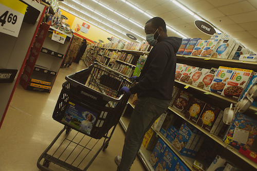 A patron at a local grocery chain dons hand protection and a mask while shopping. (Ulrich Fonou/The Washington Informer)
