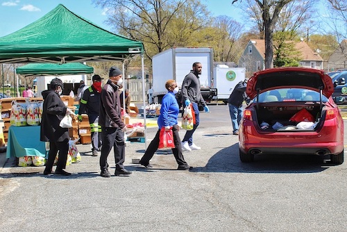 Seat Pleasant city employees, members of SHABACH! Ministries and volunteers load grocery bags into vehicles during "grab and go" grocery giveaway on April 2. (Brigette Squire/The Washington Informer)