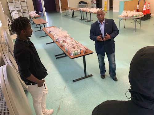 Squeegee kids Tony and Quan get a pep talk from Baltimore Mayor Jack Young before meal distribution begins at Westport Homes. (Courtesy of the Mayor's Office)