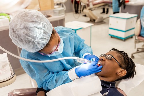 A dentist works on a patient. (Courtesy of Howard University)