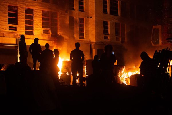 After a construction site was set on fire during riots in Minneapolis over the police killing of George Floyd, protesters gather on the site as they watched the fire on May 27, 2020. (Chris Juhn/Zenger News Service)