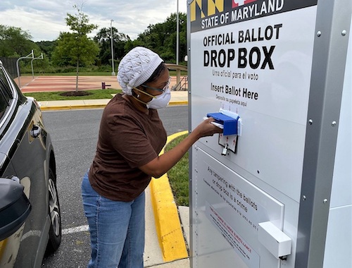 Nicole Clendenin of Bowie, Maryland, places four ballots in a drop box outside the Kentland Community Center in Landover on June 2, the day of the state's primary election. (William J. Ford/The Washington Informer)
