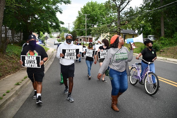 Krystal Oriadha (right) leads chants while marching through Fairmount Heights on June 22 to protest police brutality, violence against women and racism. (Anthony Tilghman/The Washington Informer)