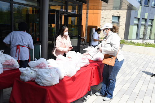 Kim R. Ford, executive director of Martha’s Table, works with staff and volunteers handing out bags of food in front of their office in southeast D.C. (Roy Lewis/The Washington Informer)