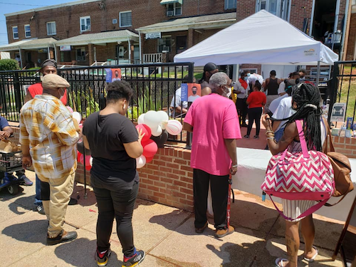 Local residents crowd the entrance of Janae Coleman's new restaurant during her food giveaway for COVID-19 relief.
