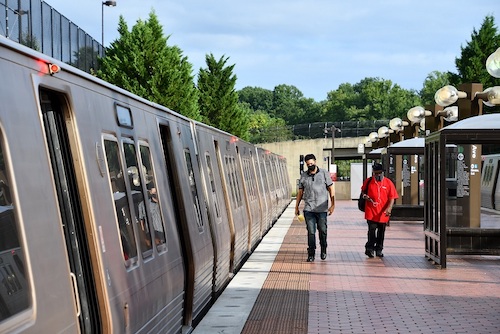 Riders prepare to board a Green Line train at the Branch Avenue Metro station. (Anthony Tilghman/The Washington Informer)