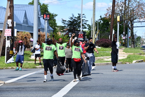 Our Time is Now (TIN) member Colby Mullins chants with passing drivers in support of the organization's Sunday Scrub event. (Courtesy photo)