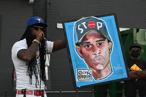 Mike D’Angelo, an anti-violence activist and uncle of the late Mikayah Wilson, speaks during a candlelight vigil for Deon Kay on Sept. 5, where he presented a painting by Demont Pinder of the late Kay. (Roy Lewis/The Washington Informer)