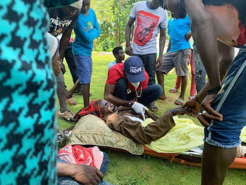 Project HOPE team members work to load a landslide survivor onto a U.S. Coast Guard helicopter for transport to Port-au-Prince. The man had been buried in a landslide for a week and had a broken femur and was suffering from dehydration and hunger. (Courtesy of Project Hope)