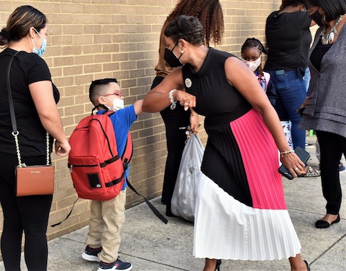 Prince George's County Public Schools CEO Monica Goldson greets a Deerfield Run Elementary student with an elbow bump on Sept. 8, the first day of school in the county. (Robert R. Roberts/The Washington Informer)