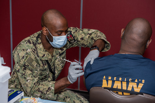 Hospital Corpsman 2nd Class James Owen, from Tobyhanna, Pa., administers the Pfizer vaccine to a Sailor onboard Naval Air Facility Atsugi Sept. 8, 2021. COVID-19 vaccination is now mandatory for Active Duty and Ready Reserve Department Of Defense service members who are not medically or administratively exempt. (U.S. Navy photo by Mass Communication Specialist 3rd Class Rafael Avelar)