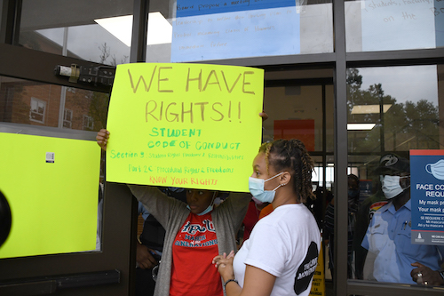 Howard University senior Aniyah Vines stands with a classmate holding up a sign at the university's Blackburn Center during a student sit-in on Oct. 13. (Anthony Tilghman/The Washington Informer)