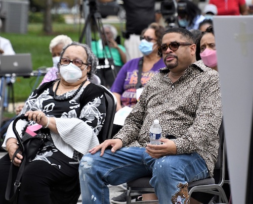 Gospel singer Byron Cage (right) sits besides his mother and a Cameron Grove resident at a community rally on Oct. 13. (Anthony Tilghman/The Washington Informer)