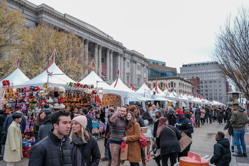 A number of shoppers go without face coverings at the downtown D.C. holiday market in Penn Quarters days after Mayor Muriel Bowser lifted the city's mask mandate. (Ja'Mon Jackson/The Washington Informer)