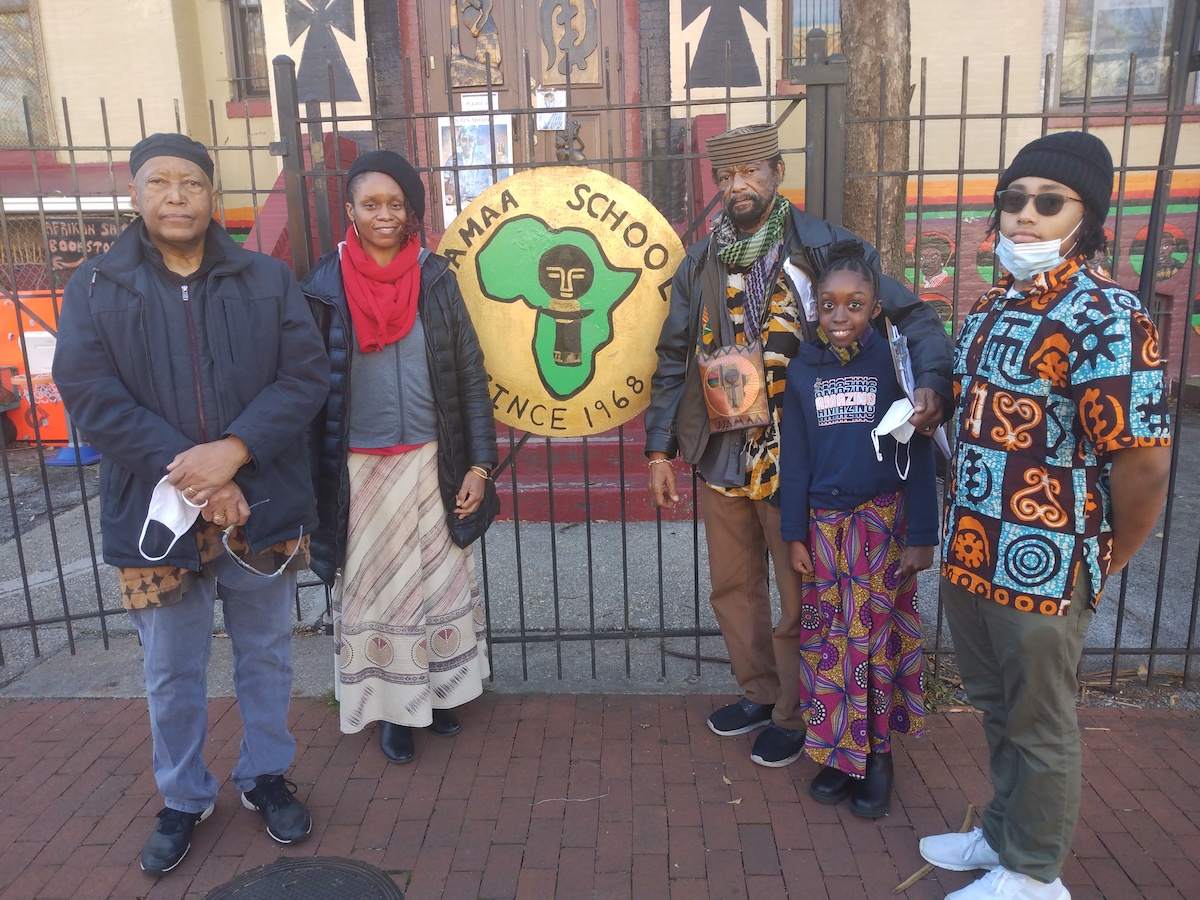 Ujamaa Shule teachers Harold Bartrum and Akina Zulu, along with founder and director, Dr. El Senzengakulu Zulu, and students Abena Bonsu and Osei Dinizulu, stand at the front gate of the school, located on Q Street between 8th and 9th streets in northwest D.C. (Sam P.K. Collins/The Washington Informer)