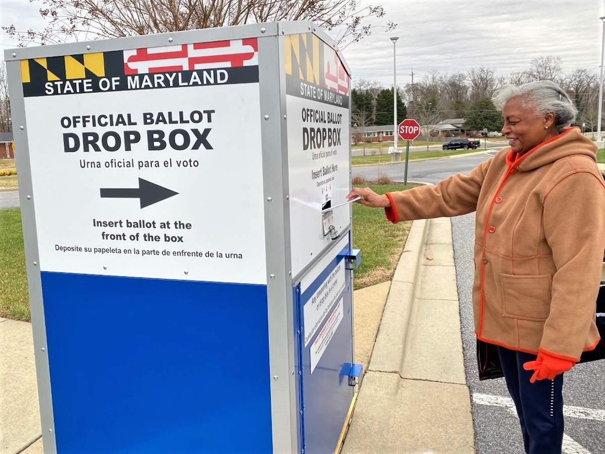 Dorothy Newby places a mail-in ballot inside a drop box outside the Southern Regional Technology and Recreation Complex in Fort Washington, Maryland, on Dec. 27, the first day of early voting in a special primary election for the Prince George's County Council's District 8 seat. (William J. Ford/The Washington Informer)