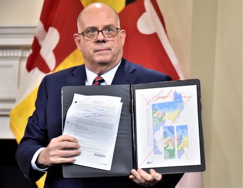Maryland Gov. Larry Hogan speaks to reporters at the State House in Annapolis on Dec. 9 while holding a folder showing his veto of a state redistricting bill sent to his desk. (Robert R. Roberts/The Washington Informer)
