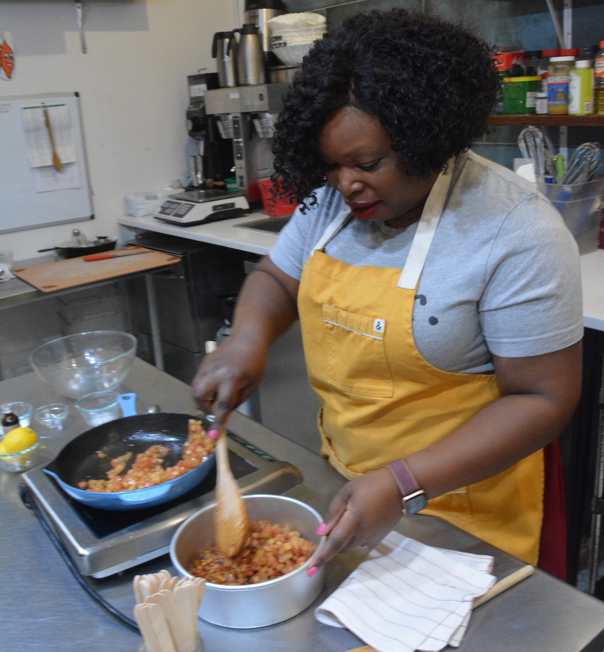 Tanorria Askew, author of “Staples +5,” prepares Apple Pie Dip and Cinnamon Sugar Chips at Bold Fork Books in the Mt. Pleasant neighborhood of D.C. on March 23. The culinary bookshop also gives cooking demonstrations. (Roy Lewis/The Washington Informer)