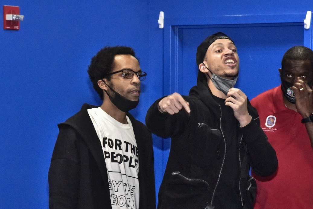 Antonio Mingo (center) pulls down his mask to express his frustration about people from the Suitland, Maryland, area not being able to attend the community meeting at Creative Suitland on April 14. Kenneth Clark (left) stands beside Mingo. (Robert R. Roberts/The Washington Informer)
