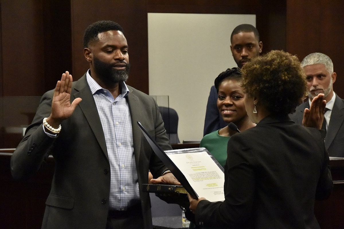 Former District Heights, Maryland, Mayor Johnathan Medlock (left) is sworn in as a interim member of the Prince George's County Council by Mahasin El Amin, clerk of the county's circuit court, during a ceremony May 9. Medlock fills vacated District 6 seat on the council until December. (Robert R. Roberts/The Washington Informer)