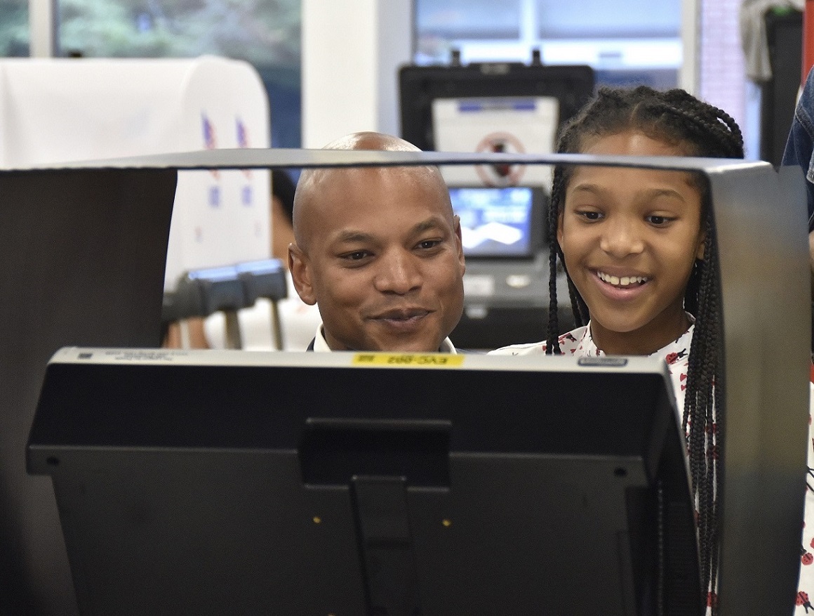Maryland Democratic gubernatorial candidate Wes Moore votes alongside his daughter Mia in Baltimore on July 7, the first day of early voting in the state primary election. (Robert R. Roberts/The Washington Informer)