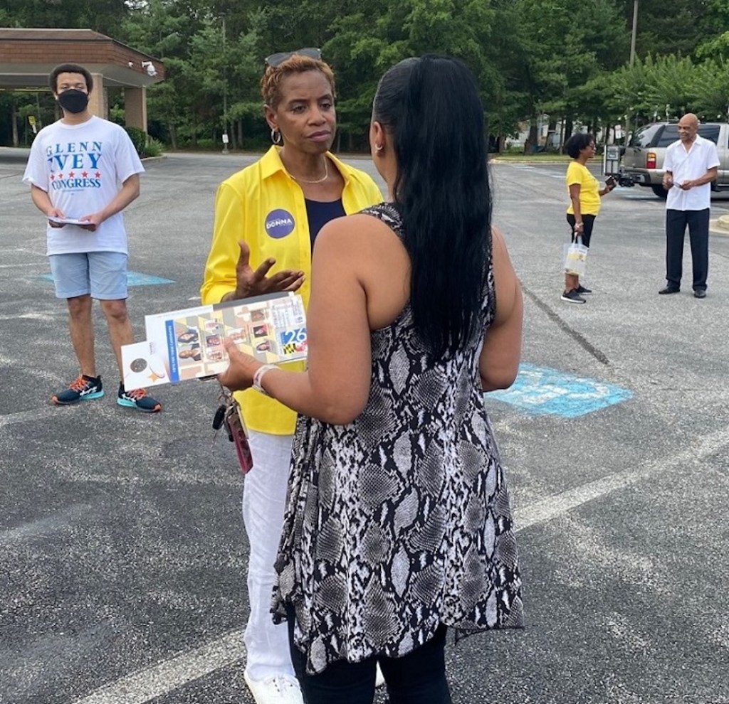 Former Rep. Donna Edwards chats with Diane Young before she casts her vote for Edwards on July 19 at the Breath of Life Seventh-Day Adventist Church in Fort Washington. (William J. Ford/The Washington Informer)