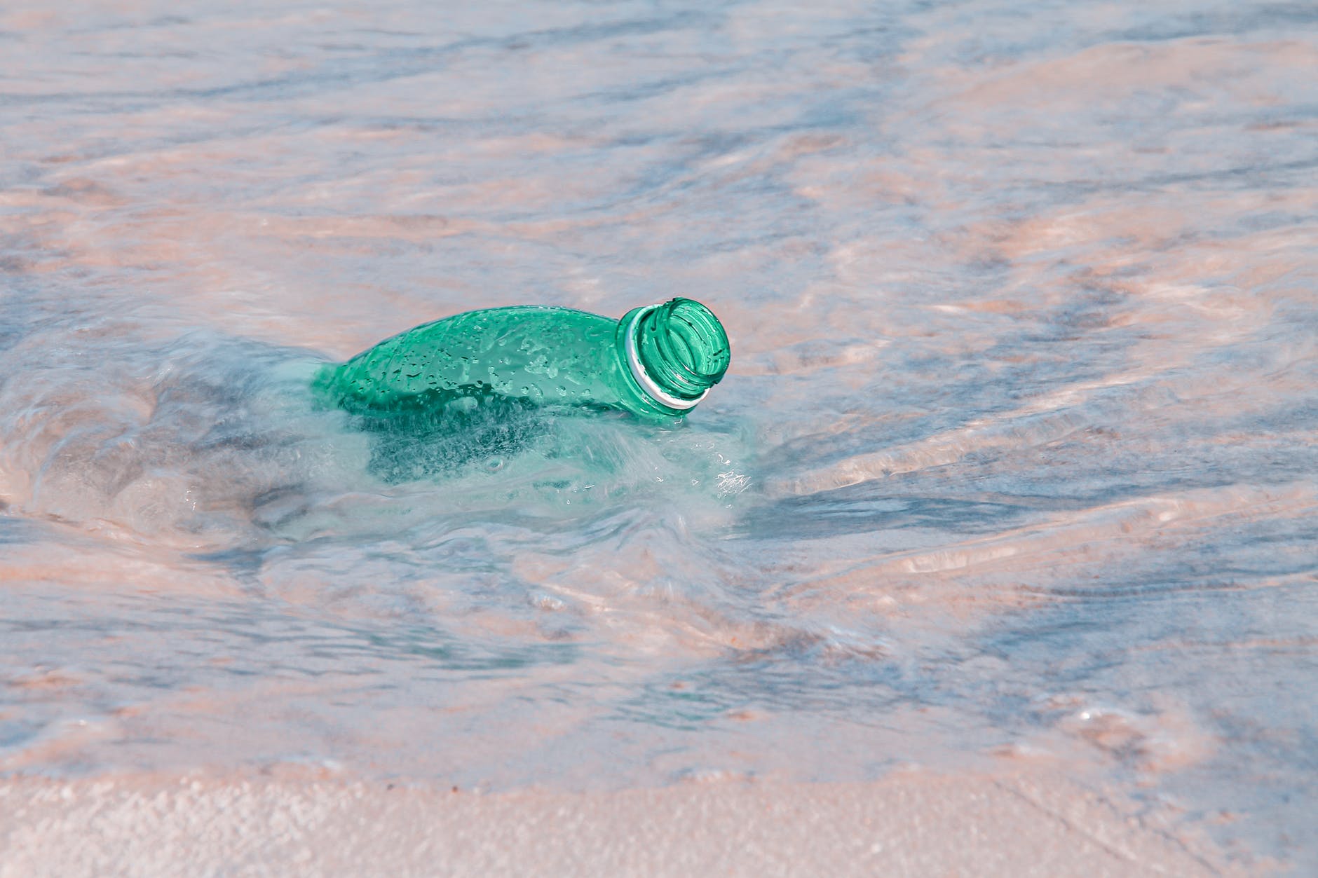 green plastic bottle on water