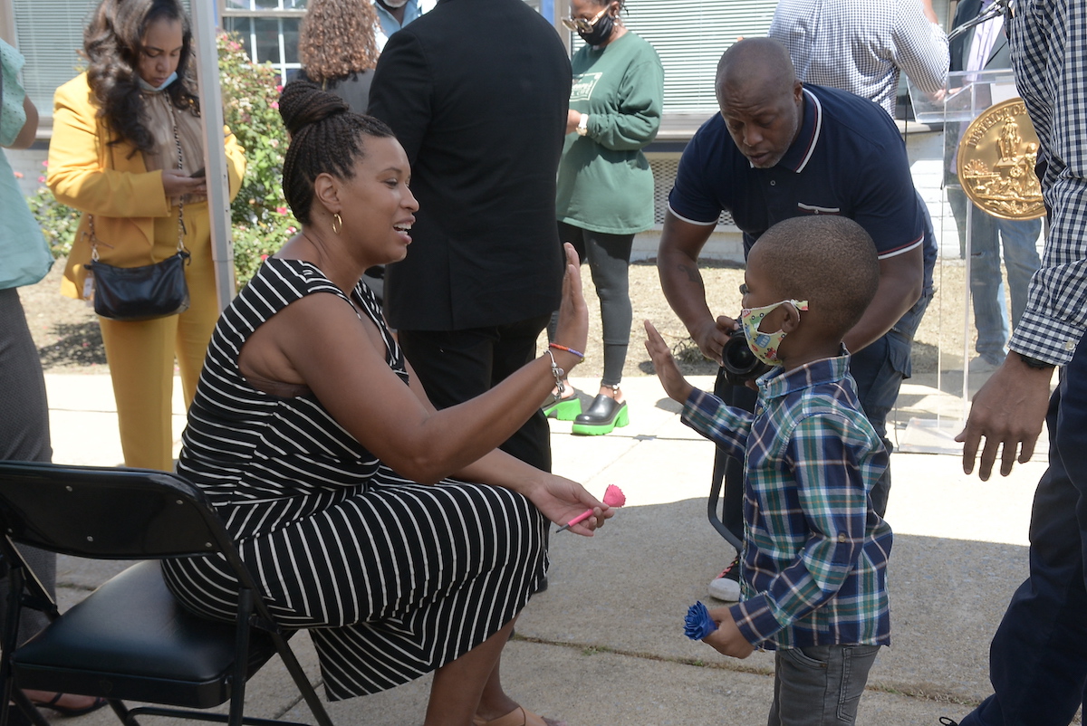 D.C. Mayor Muriel Bowser gives a high-five to 4-year-old Frankie after a press conference on Aug. 18 in Northwest announcing the one-time back-to-school payment of $1,000 to D.C. families receiving TANF. (Roy Lewis/The Washington Informer)