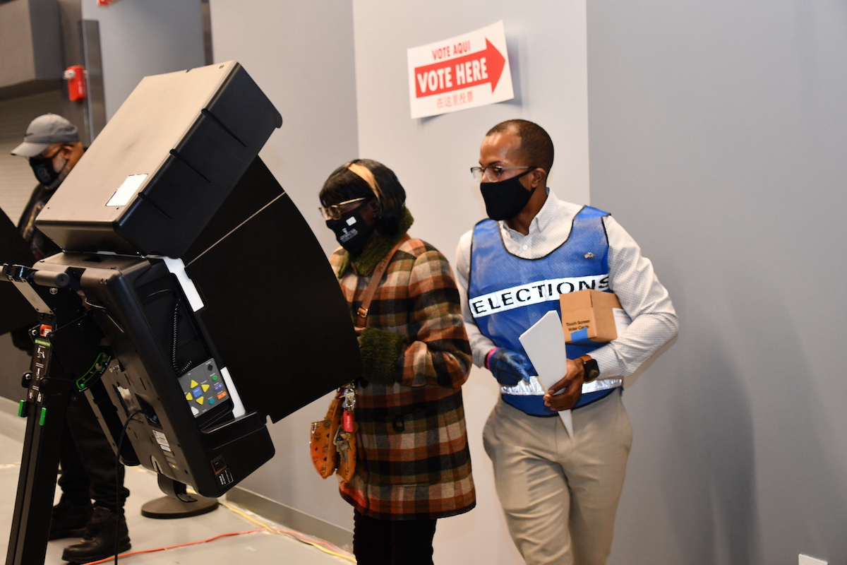**FILE** Election staff assist a voter at a polling station. (Anthony Tilghman/The Washington Informer)