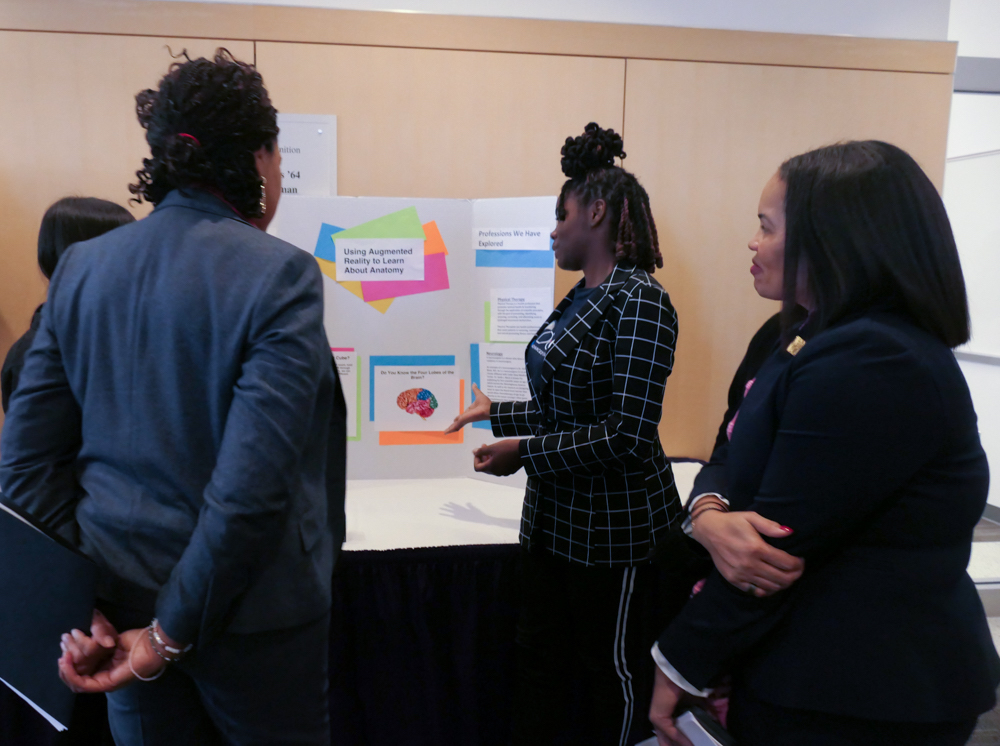 **FILE** Zaicoria McLean (center), a 9th grader at Bell Multicultural High School, presents a project she worked on with Laylah Malloy and Teresa Jimenez, 11th graders at Jackson Reed High School, to D.C. Mayor Muriel Bowser (left) and Office of the State Superintendent of Education Christina Grant (right) at the District’s Advanced Technical Center at Trinity Washington University in Northeast on Nov. 14. (Shevry Lassiter/The Washington Informer)