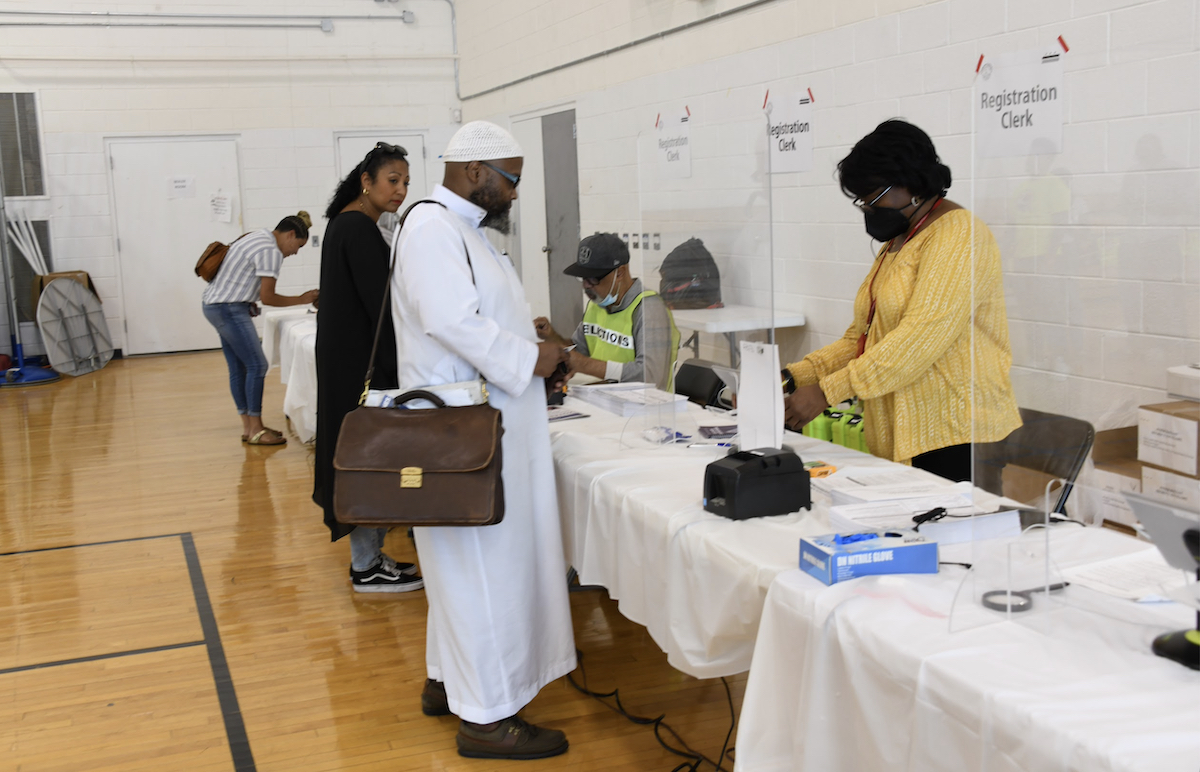 **FILE** Voters stop at the registration desk before casting their ballots. (Anthony Tilghman/The Washington Informer)