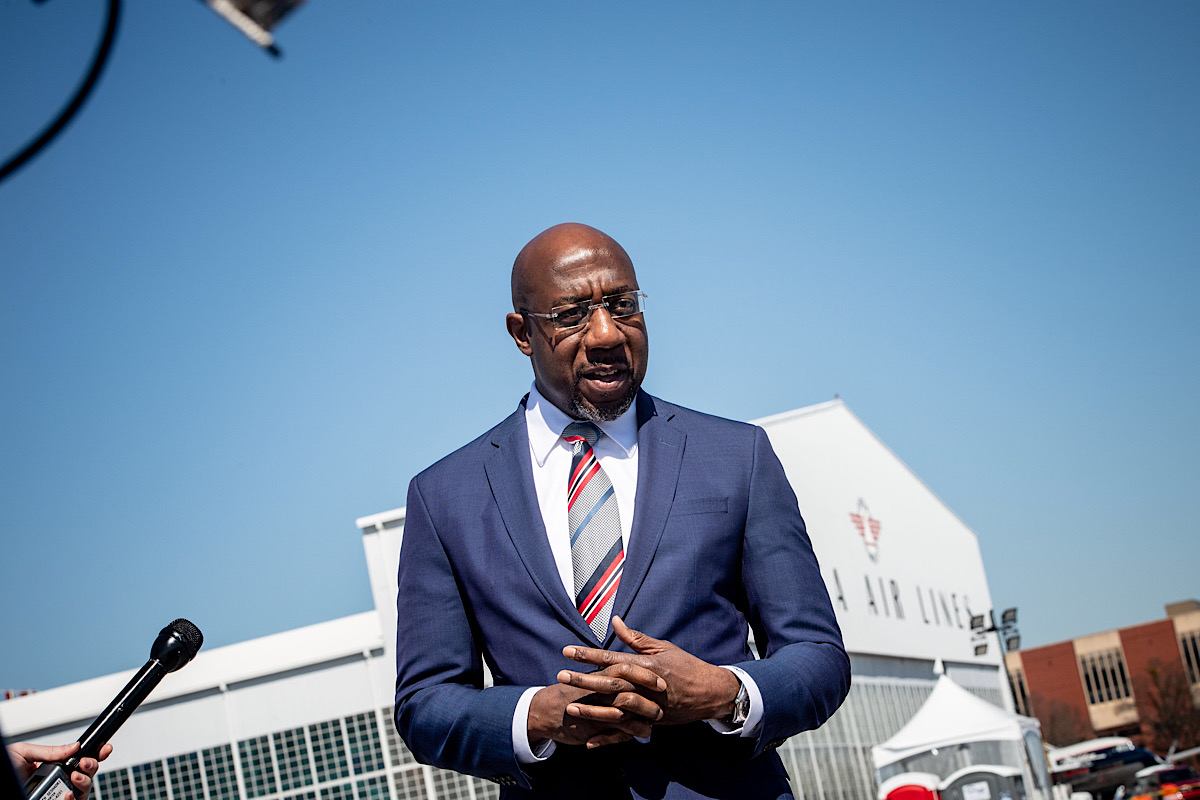 **FILE** Sen. Raphael Warnock visits the COVID-19 mass vaccination site at the Delta Air Lines Flight Museum in Atlanta, Ga., on March 8, 2021. (DeltaNewsHub via Wikimedia Commons)
