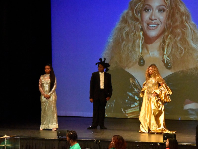 Young actors Tatum Primus (as Jennifer Hudson), John Madden (as Jay-Z) and Kennedi Grimes (as Beyoncé) at the Kennedy Center's Millennium Stage with a projected image of Grammy-winning artist Beyoncé in the background (Robert R. Roberts/The Washington Informer)