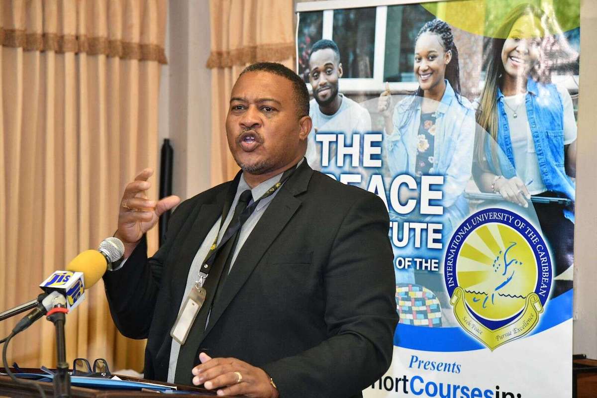 Richard Troupe, director of Safety and Security at the Ministry of Education and Youth, speaks at the Peace Symposium. (Courtesy photo)