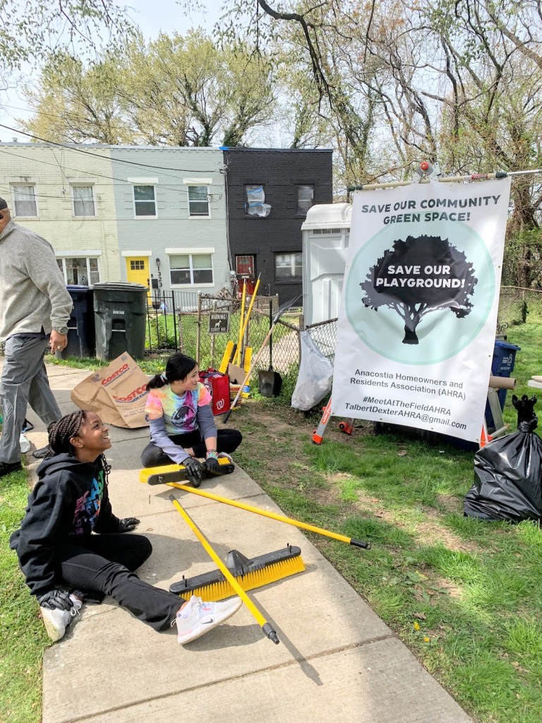 Kids from the neighborhood help out with the April 8 community cleanup, which doubled as a rally. (Kayla Benjamin/The Washington Informer)