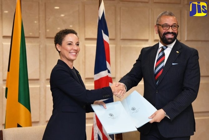 Sen. Kamina Johnson Smith (left), Jamaica’s minister of foreign affairs and foreign trade, and James Cleverly, secretary of state for foreign, commonwealth and development affairs of the United Kingdom, signing document (Courtesy of Jamaica Information Services)