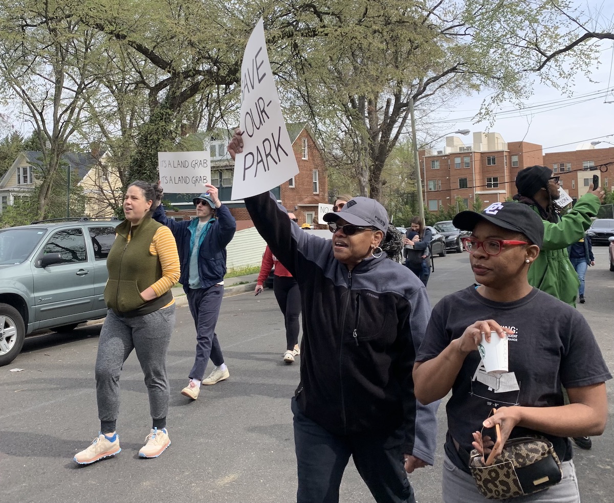 Karen Hilliard (center) joins other Talbert Terrace neighborhood residents in a short march on April 8 in support of protecting a beloved community green space. (Kayla Benjamin/The Washington Informer)