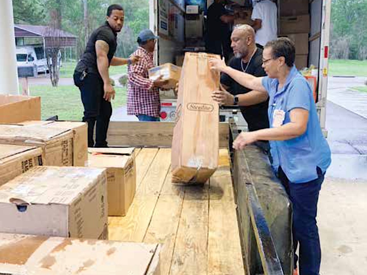 Rev. Roderick Lewis, pastor of the New Beginning Missionary Baptist Church in Natchez, Mississippi, and volunteers load items to ship to Rolling Fork. (Roy Lewis/The Washington Informer)