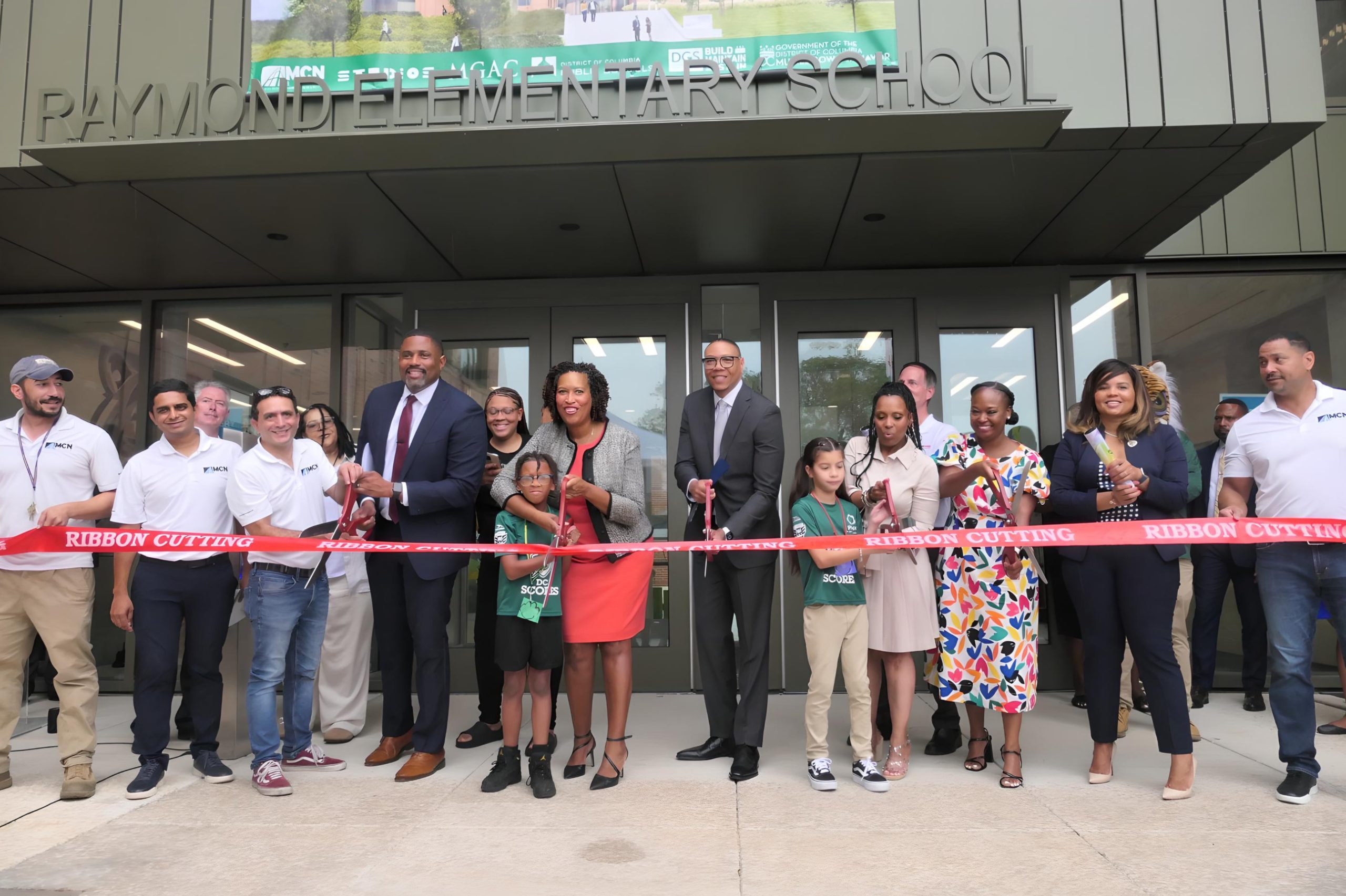 Mayor Muriel Bowser, D.C. Public Schools Chancellor Lewis Ferebee, Raymond Elementary School Principal Natalie Hubbard and other education leaders welcome students to the modernized Raymond Elementary School campus on Aug. 28 during a ribbon-cutting ceremony for the renovated facility. (Shevry Lassiter/The Washington Informer)