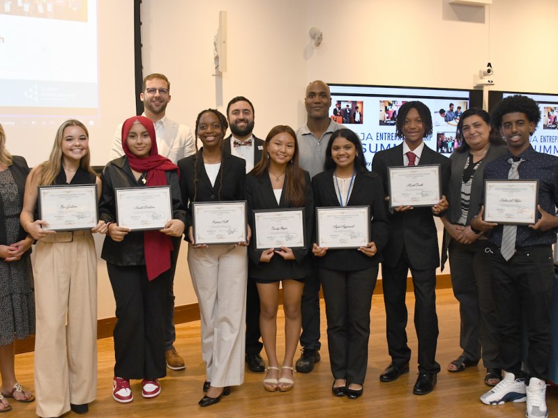 The Eco-Excursions Junior Achievement team stands with some of the judges, earned first place in the 2023 Junior Achievement Entrepreneur Summit Pitch Competition. From left: Erin Graham, Norah Brahimi, Kierra Hall, Sandy Fligan, Ayati Aggarwal, Micah Smith and Nathaniel Asfaw. (Anthony Tilghman/The Washington Informer)