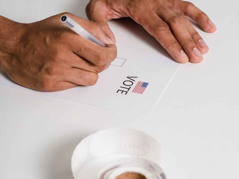 a person writing on white paper