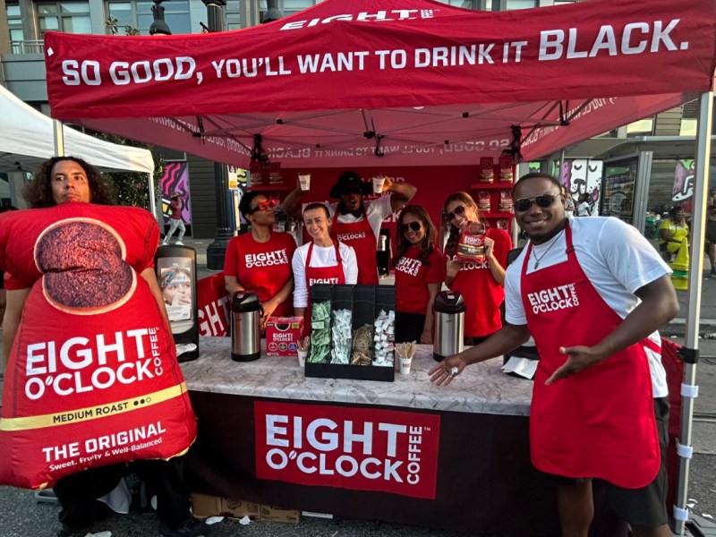 Representatives from Eight O’Clock Coffee pose on 8th and H streets in Northeast D.C. (Micha Green/The Washington Informer)