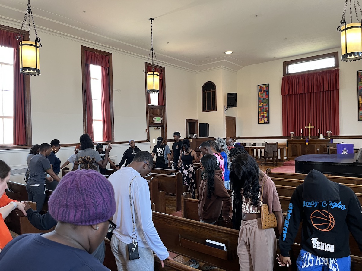 Morgan State University students pray at a church near the northeast Baltimore school after an on-campus shooting incident on Oct. 3 left five injured. (WI photo)