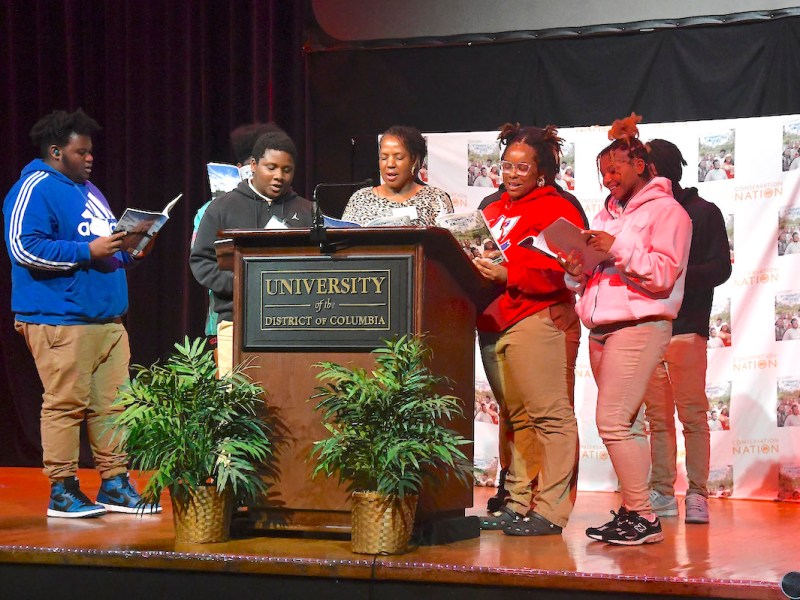 The student co-authors of the new book “Through My Anacostia Eyes” and the book’s editor, Caroline Brewer, read aloud at a book launch at the University of the District of Columbia on Nov. 8. (Robert R. Roberts/The Washington Informer)