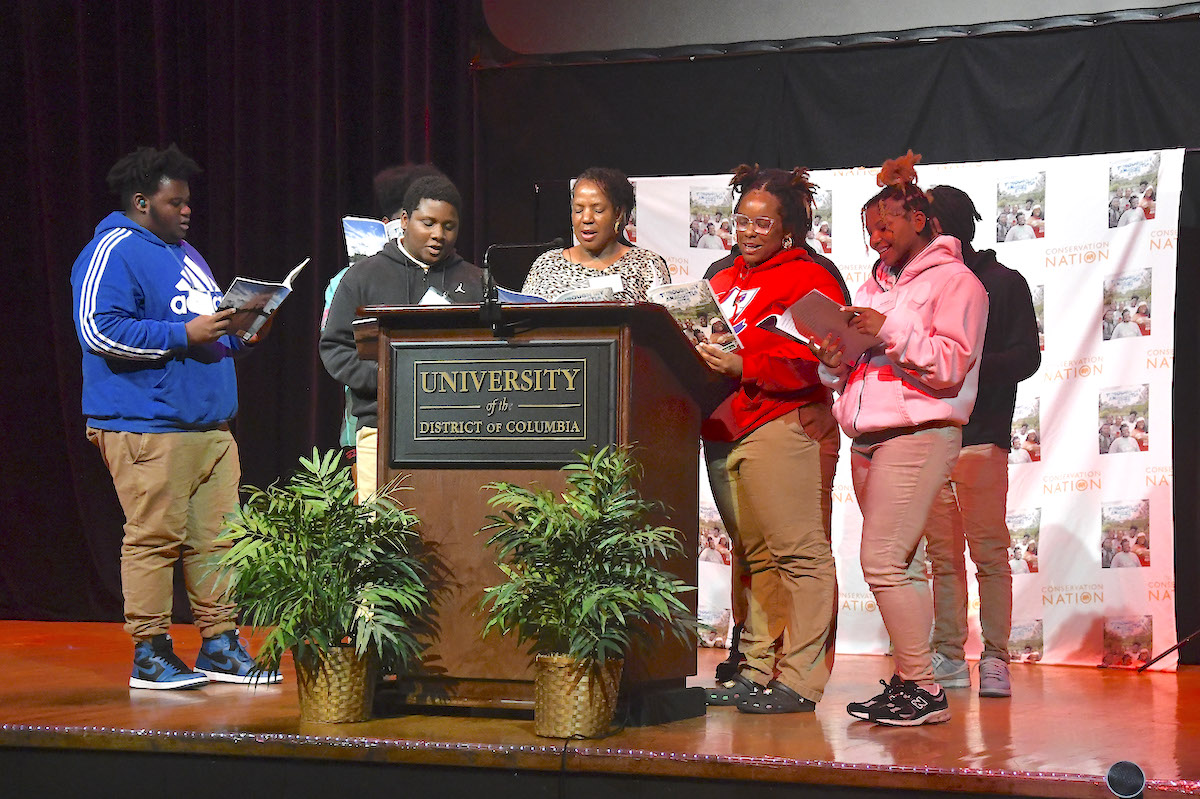 The student co-authors of the new book “Through My Anacostia Eyes” and the book’s editor, Caroline Brewer, read aloud at a book launch at the University of the District of Columbia on Nov. 8. (Robert R. Roberts/The Washington Informer)