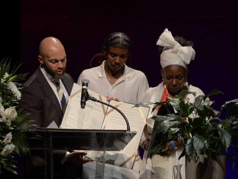 At-Large Council member Robert White presents a resolution in honor of Sandra Butler-Truesdale’s service to the District, to her daughter and grandson Tonya Butler-Truesdale and Logan Butler Henderson. Hundreds gathered in the Kennedy Center’s Terrace Theater for the celebration of life for D.C. musical historian the Rev. Sandra Butler-Truesdale on Nov. 15. (Roy Lewis/The Washington Informer)
