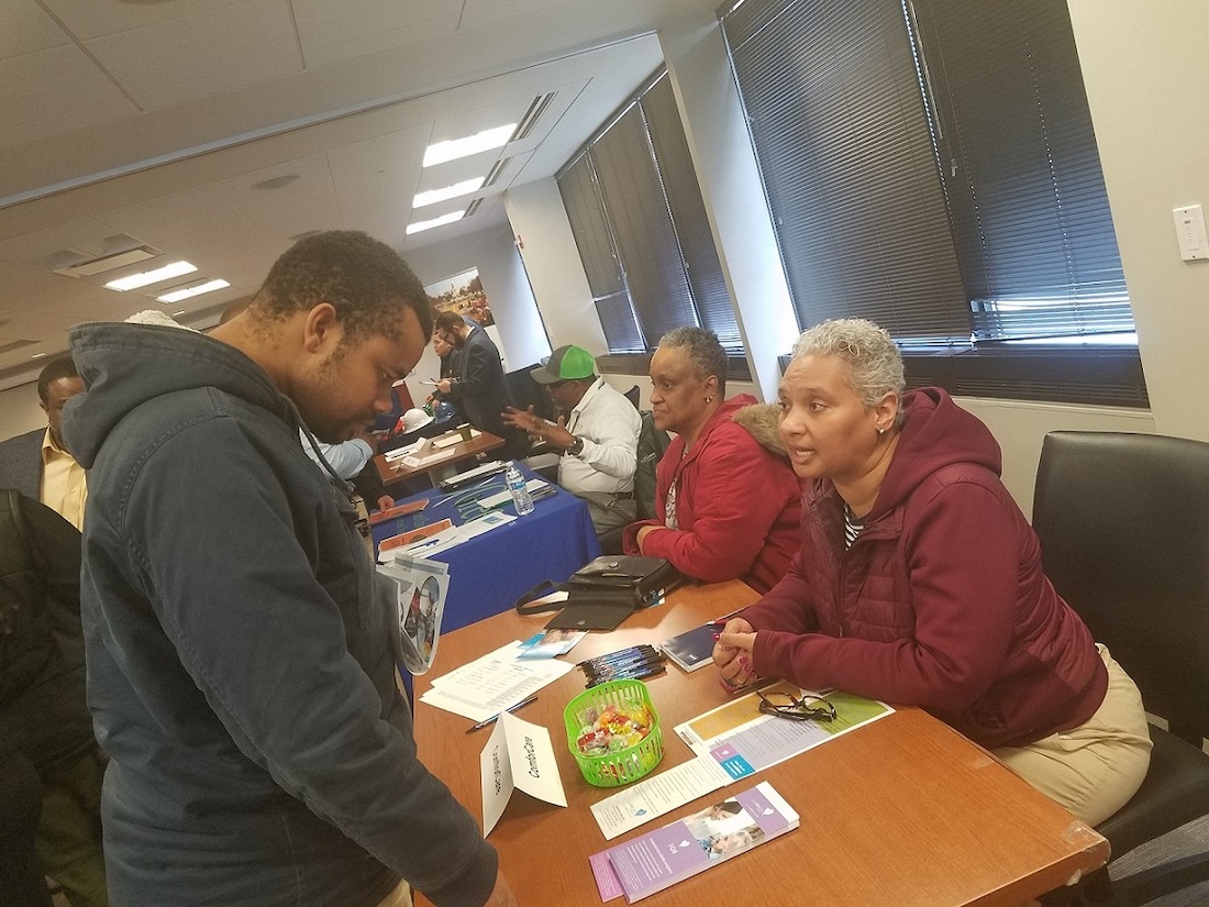 **FILE** Adrienne Pritchett (right), an office manager at ComForCare, chats with Aaron Williams at Employ Prince George's "2nd Chance" job fair in Largo, Maryland, on March 22, 2019. (William J. Ford/The Washington Informer)